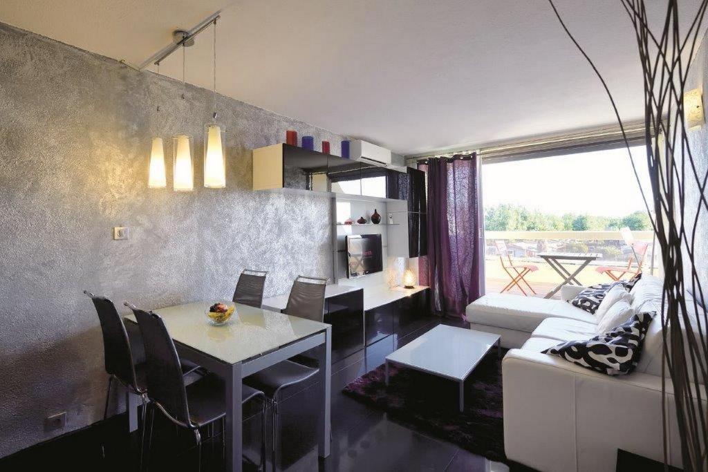 un salon avec une table et un canapé dans l'établissement Studio MAYA - Héliopolis L 84 - Chic - 2 personnes, au Cap d'Agde