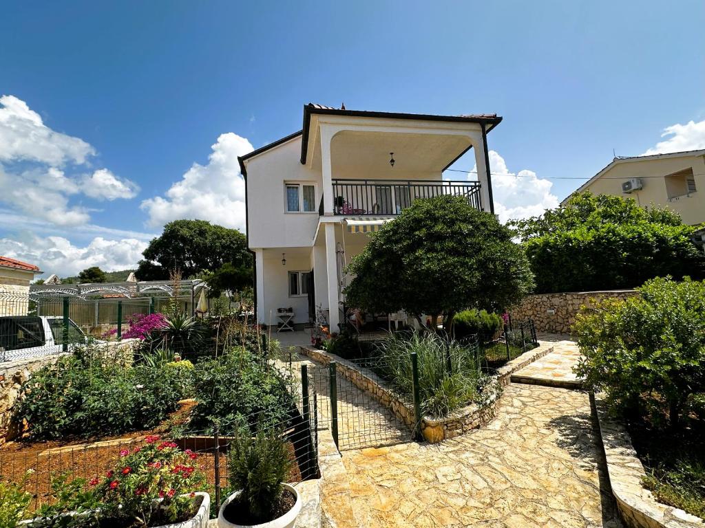 a house with a garden in front of it at Apartment Second Home in Tribunj