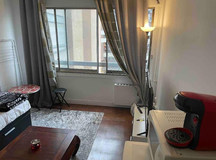 un salon avec un canapé et une fenêtre dans l'établissement Studio à Paris 20eme, à Paris