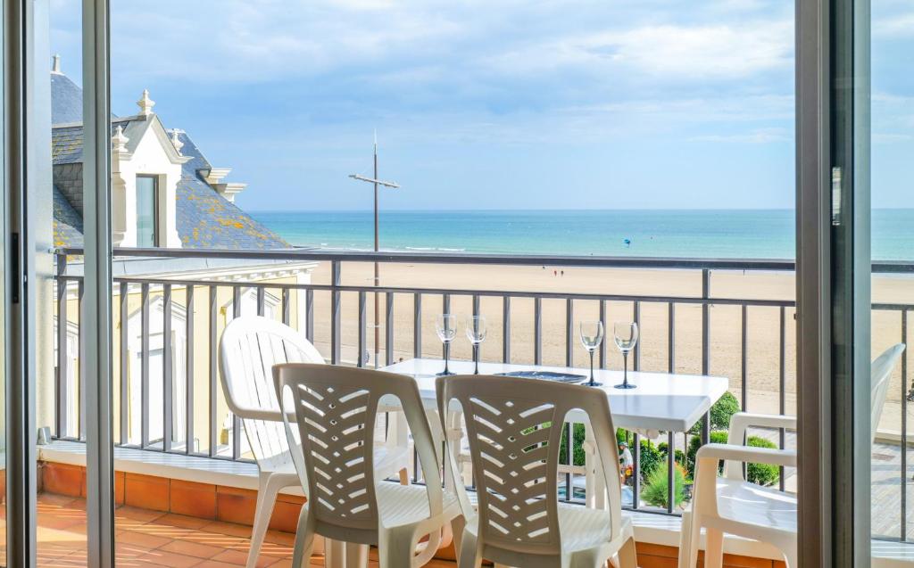 une table et des chaises sur un balcon avec vue sur la plage dans l'établissement Appartement avec vue sur la baie des Sables d'Olonne - 4 personnes, à Les Sables-dʼOlonne