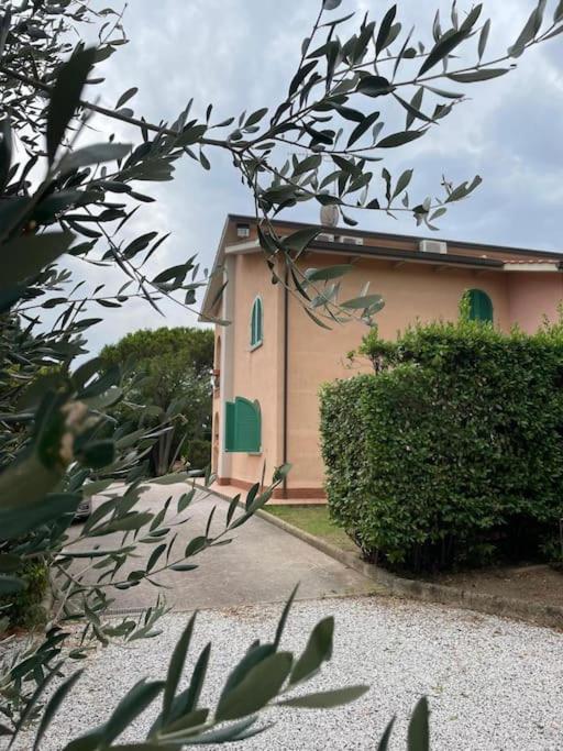 a building with green doors on the side of it at Biancolilla House in Rosignano Solvay