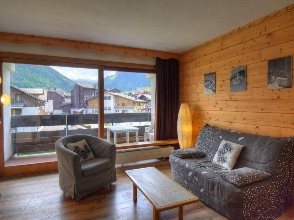 un salon avec un canapé et des chaises et une grande fenêtre dans l'établissement Studio agréable, centre de Morzine, garage, Wifi - FR-1-524-76, à Morzine
