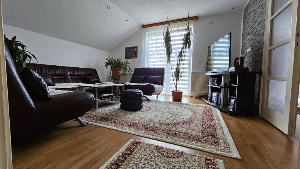una sala de estar con un sofá y una alfombra en Apartman ADO, en Sarajevo