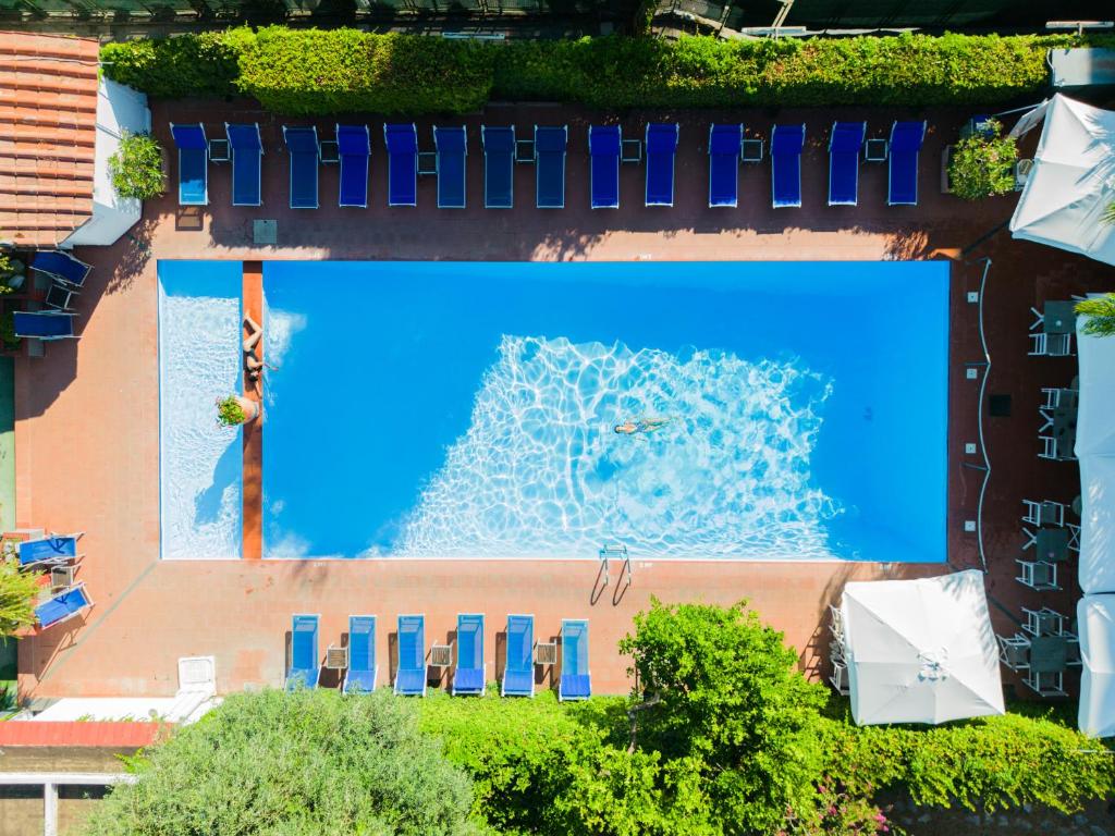 an overhead view of a swimming pool with chairs and water at Hotel Central Wellness in Sorrento