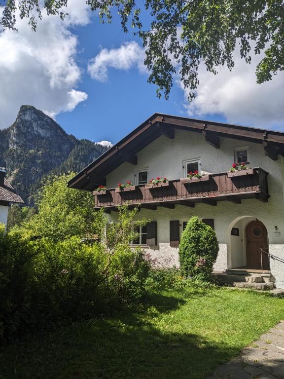 a house with a balcony with flowers on it at Ferienhaus Valentin in Oberammergau in Oberammergau