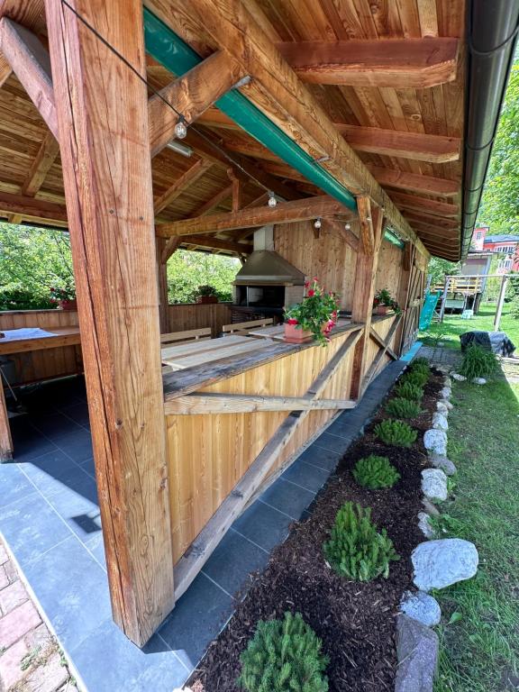 an outdoor kitchen with a wooden pergola at Dolomitihouse CASTAGNER in Fiera di Primiero