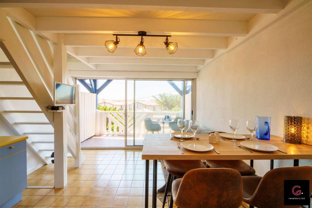 Un comedor con mesa y sillas de madera. en Duplex Biscarrosse plage pour 4 Personnes, en Biscarrosse
