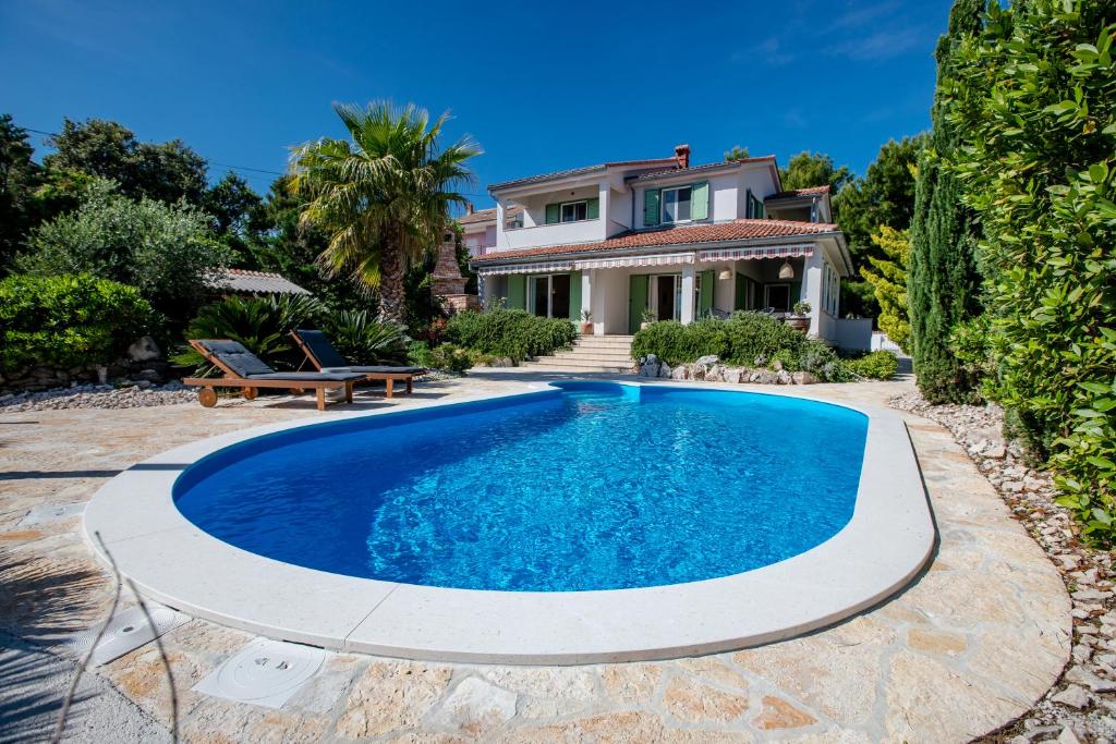 an image of a swimming pool in front of a house at Holiday House Dolin in Rab