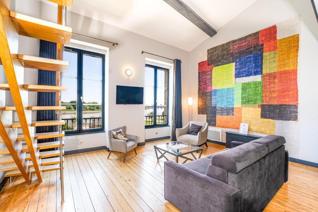 a living room with a couch and a colorful mosaic wall at Appartement Climatisé 3 Chambres Vue Garonne in Bordeaux