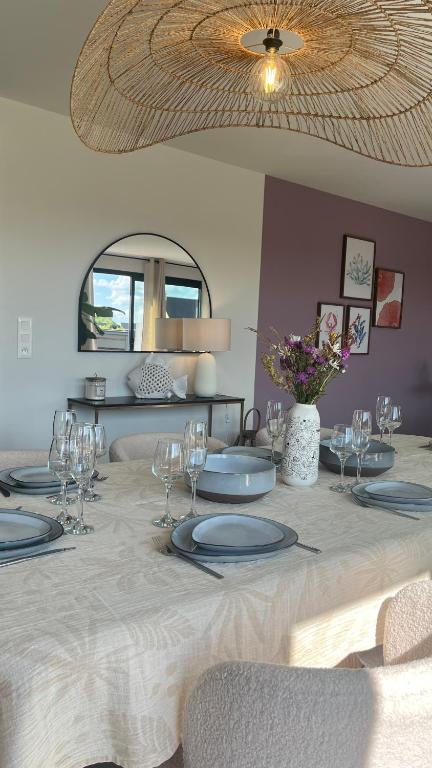 une table avec des assiettes et des verres à vin dessus dans l'établissement Villa Beau Séjour, à Fontenay-sur-Mer