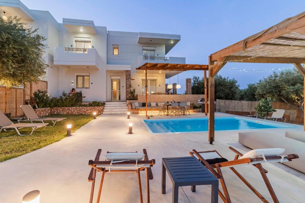 a villa with a swimming pool and a house at Villa Tranquility in Psinthos