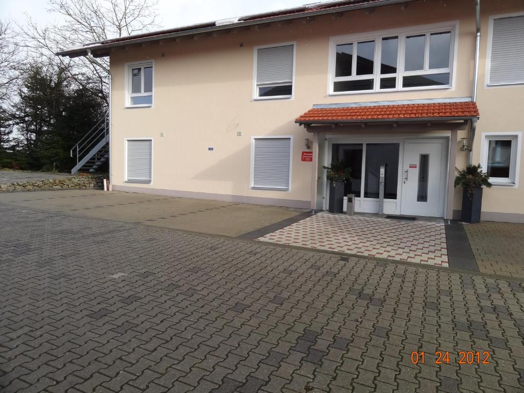 a house with a brick driveway in front of it at Pension Alram Hof in Eggenfelden