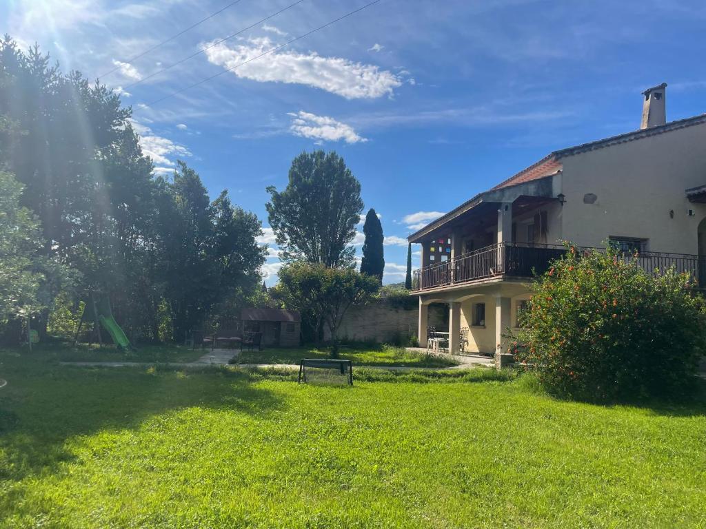 a house with a grassy yard next to a building at Appartement in Caumont-sur-Durance