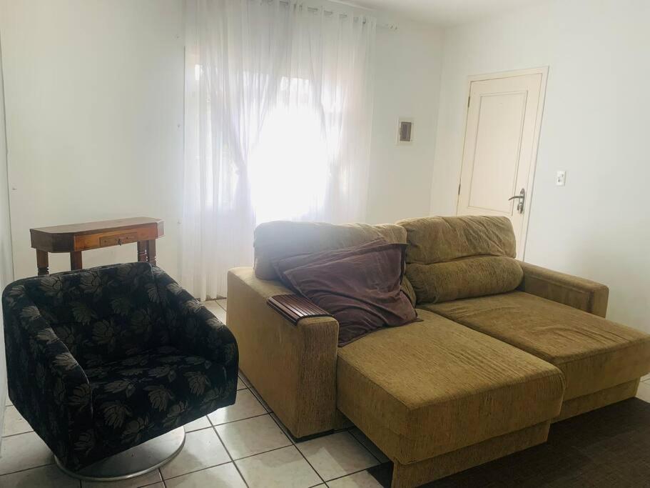 a living room with a couch and a chair at Casa Acerola in Joinville