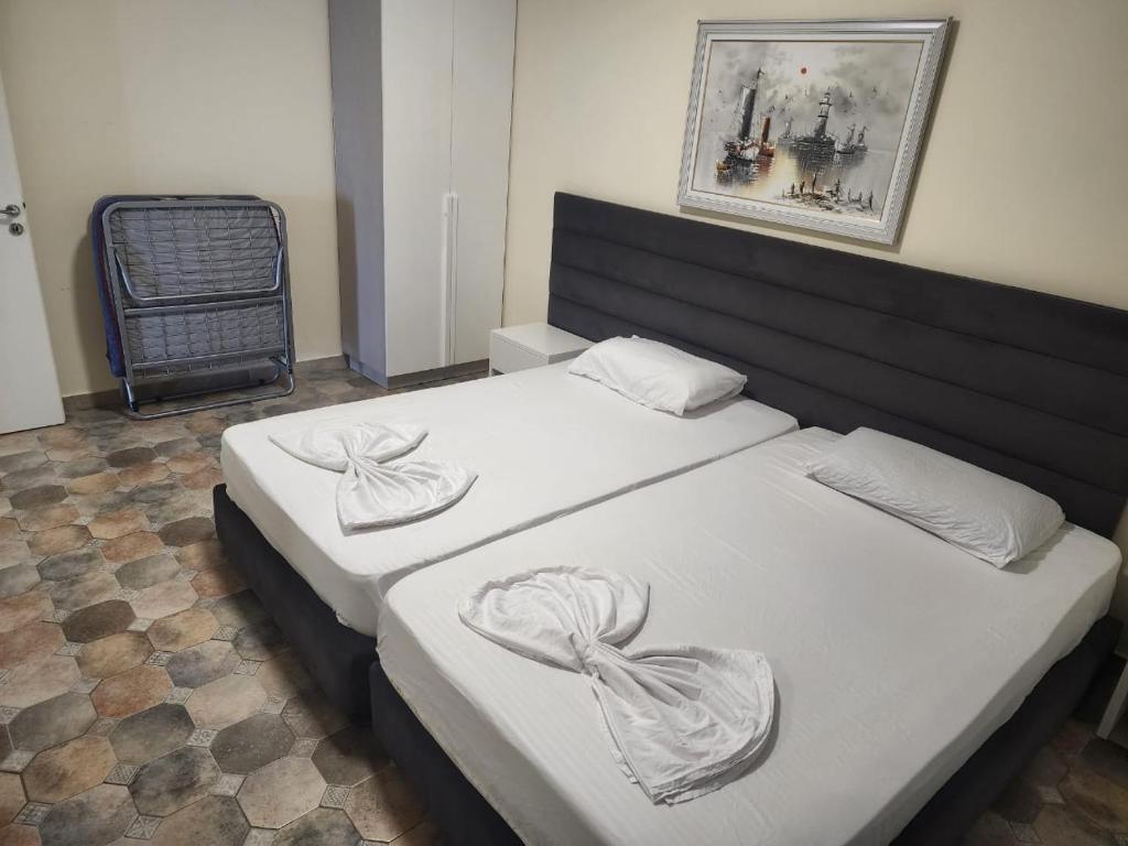 een slaapkamer met twee bedden met witte lakens bij Home holiday kozmai in Shëngjin