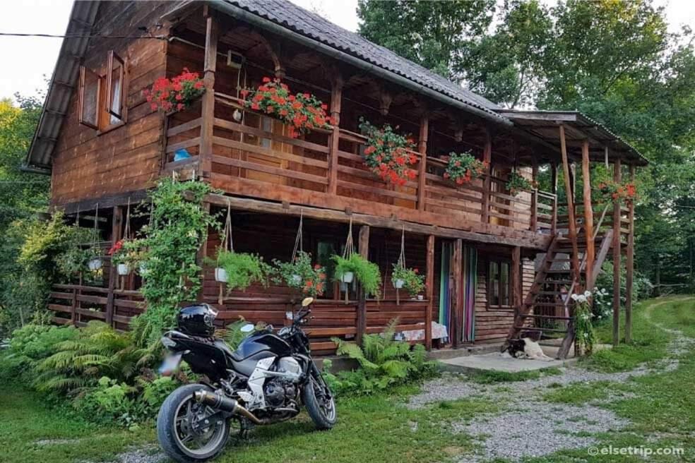 a motorcycle parked in front of a wooden house at Cabana Victor in Sighetu Marmaţiei
