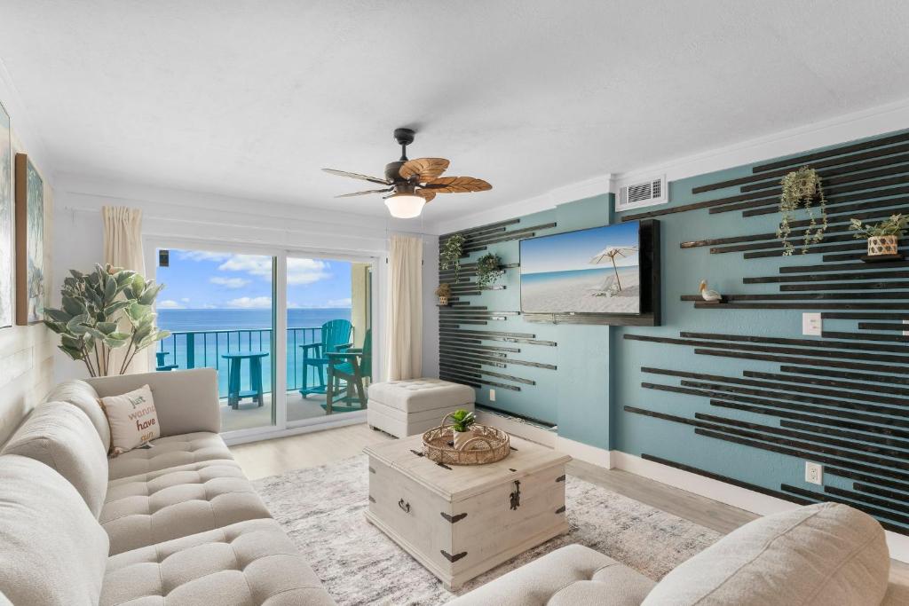 a living room with a couch and a view of the ocean at 4 Loungers 2 Umbrellas Inlc Peak Season Beachfront in Panama City Beach