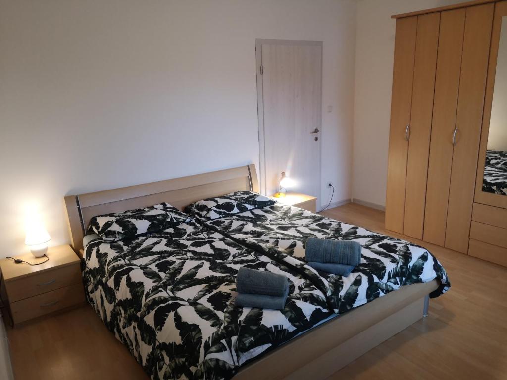 a bedroom with a black and white bed with two chairs at Sobe Zeleni raj in Podnart