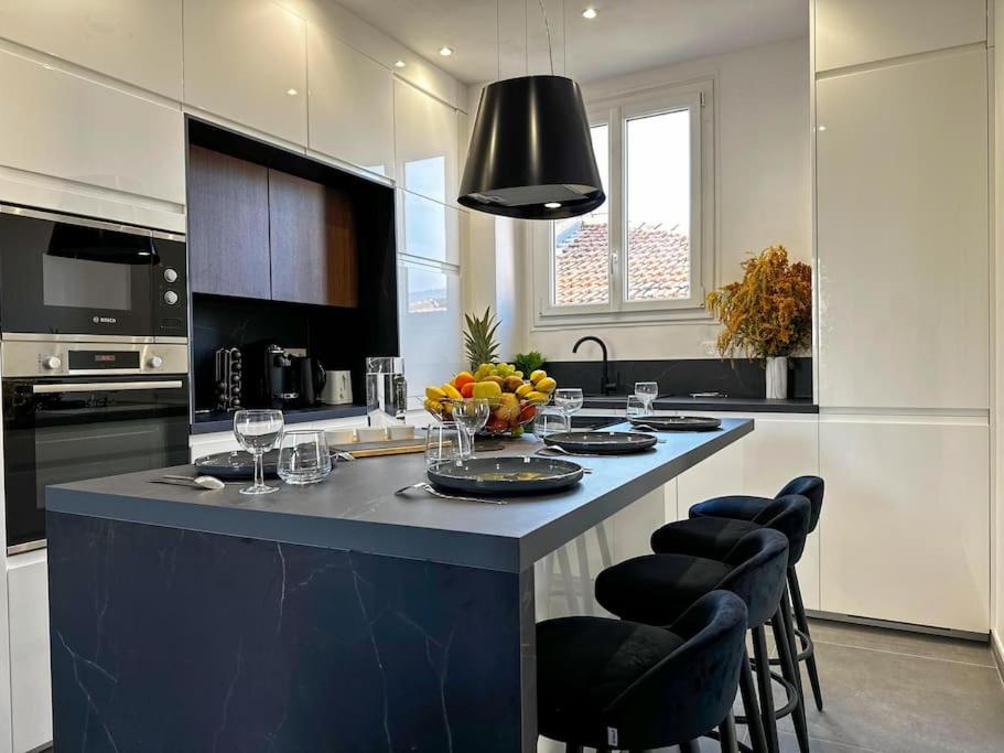 une cuisine avec une grande île dotée d'un comptoir bleu dans l'établissement Chic Renovated 2 Bedroom entire apartment or only Private Rooms in Liberation in Nice with Garage on demand, AC, Wi-Fi and Tram Access, à Nice