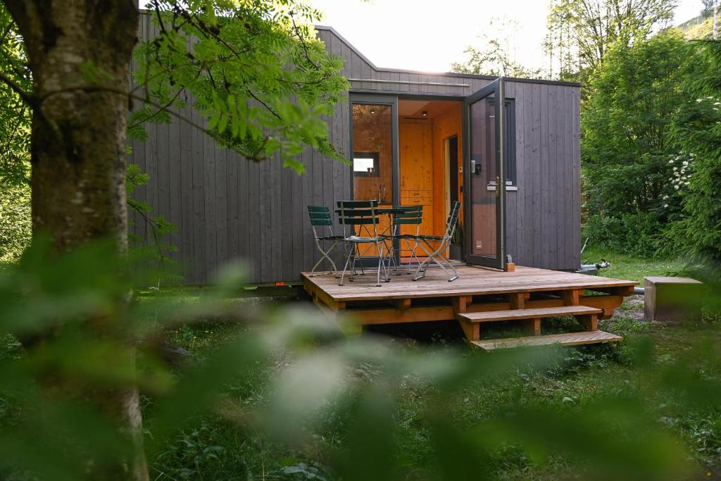 ein winziges Haus mit einem Tisch und Stühlen auf einer Terrasse in der Unterkunft Green Tiny Village Harz - Tiny House Nature 14 in Osterode