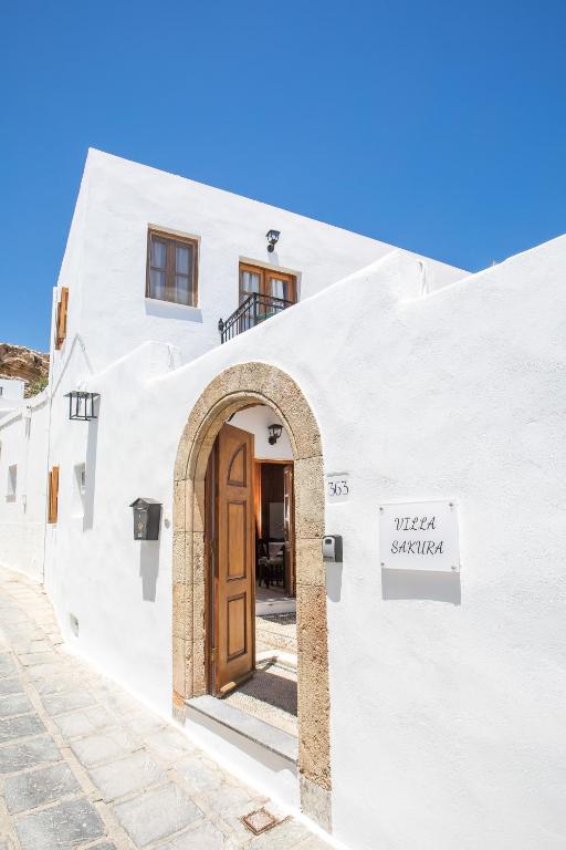 a white building with a door on a street at Villa Sakura in Lindos