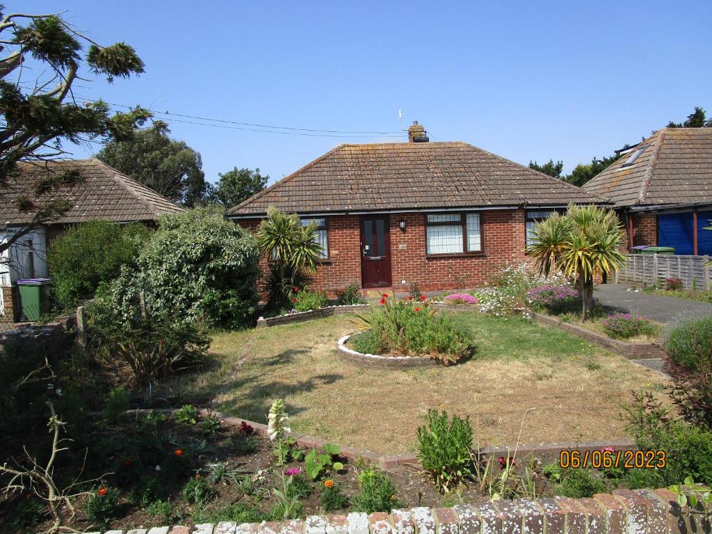 a house with a garden in front of it at Sea Shells in Greatstone