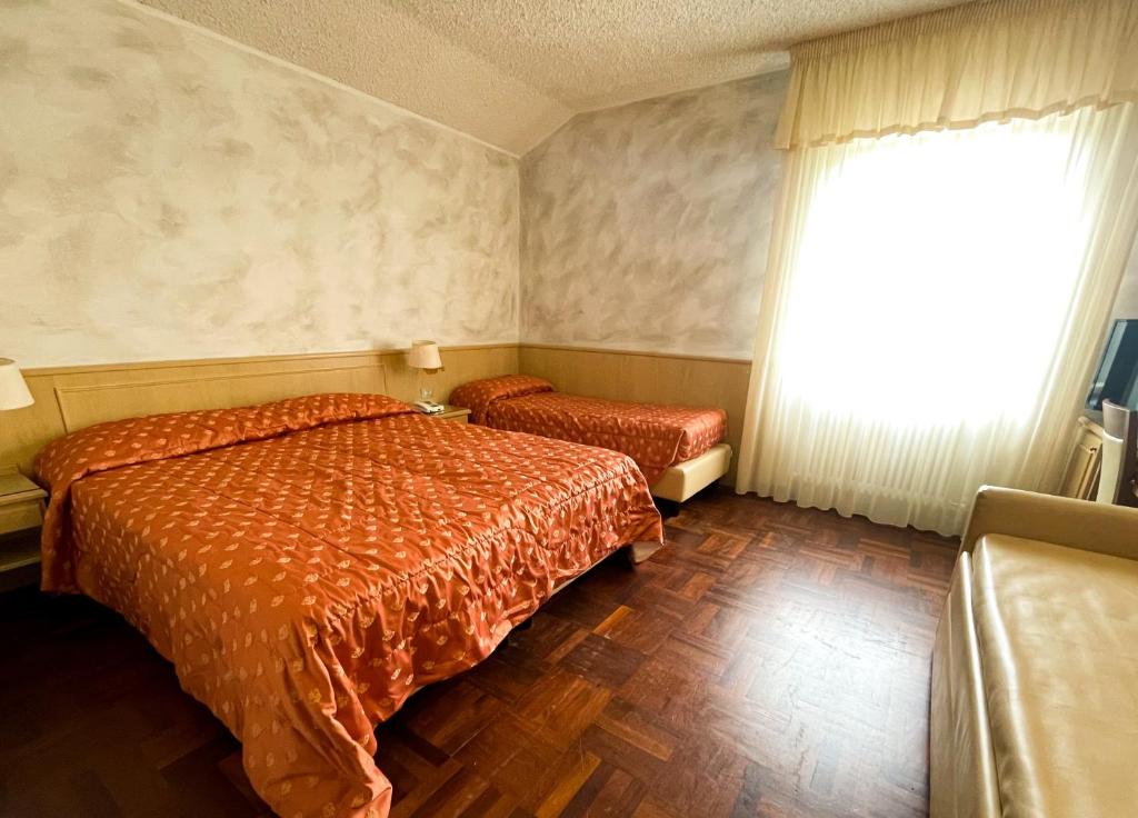 Postel nebo postele na pokoji v ubytování Hotel Garni del Lago