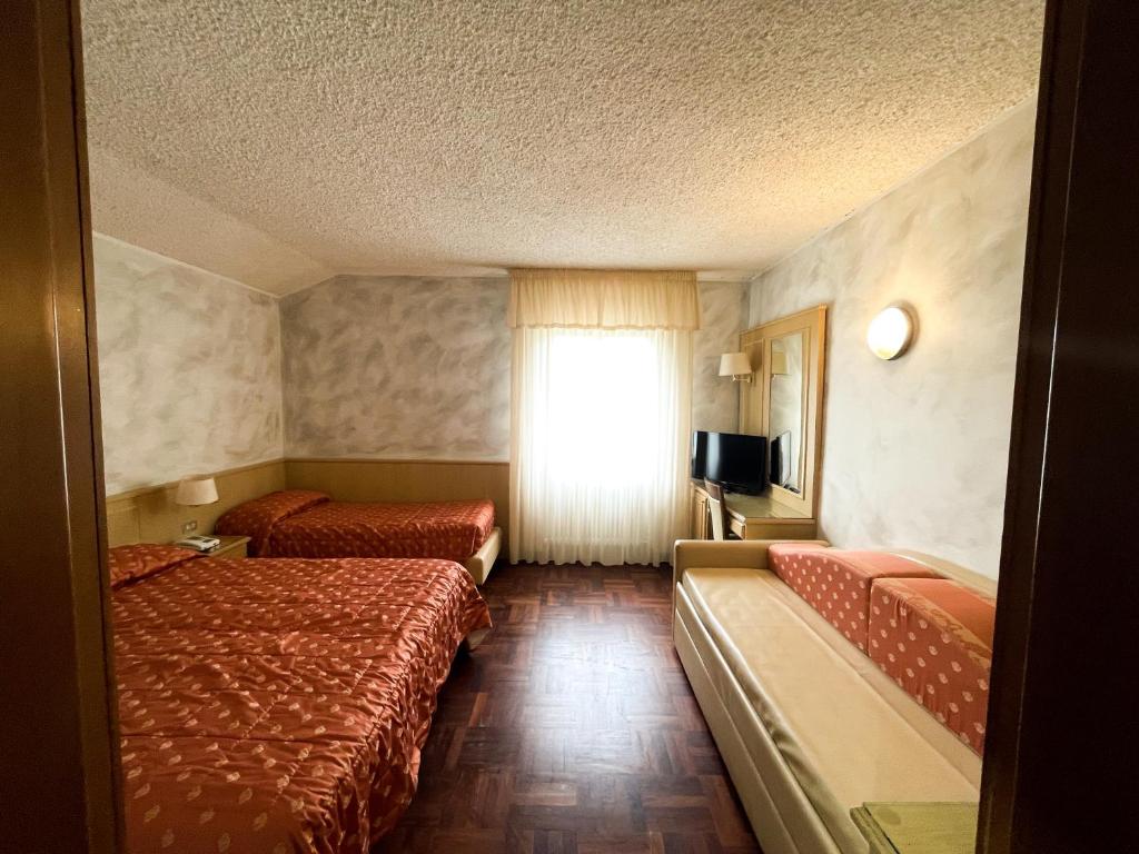 Postel nebo postele na pokoji v ubytování Hotel Garni del Lago
