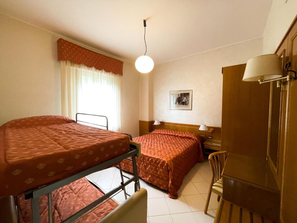 Postel nebo postele na pokoji v ubytování Hotel Garni del Lago