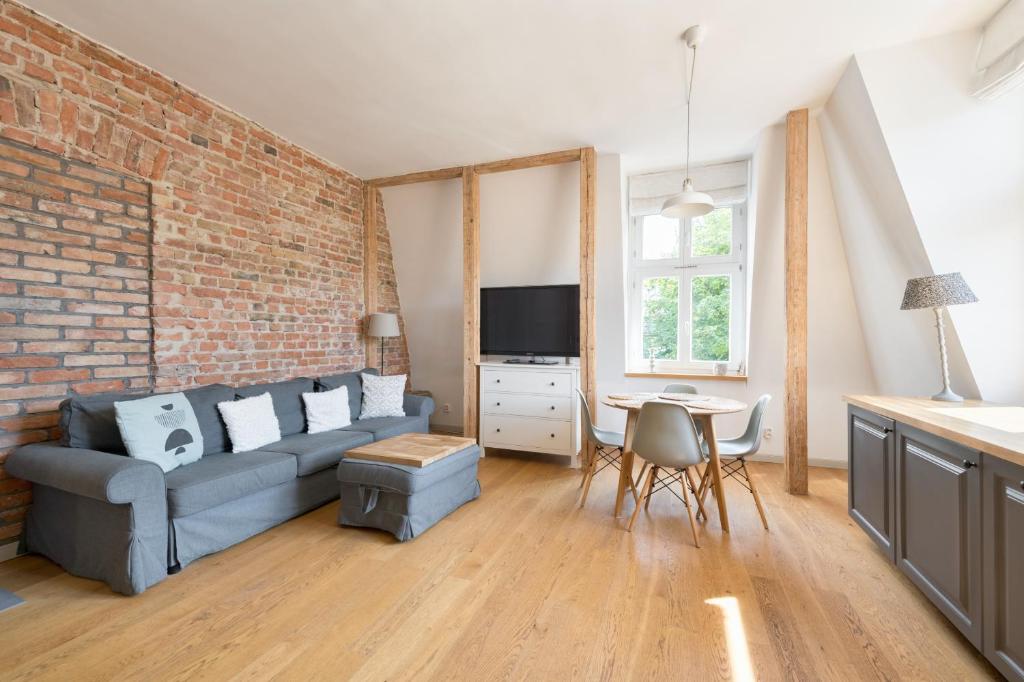 a living room with a couch and a brick wall at DR Apartments - Parkowa in Sopot