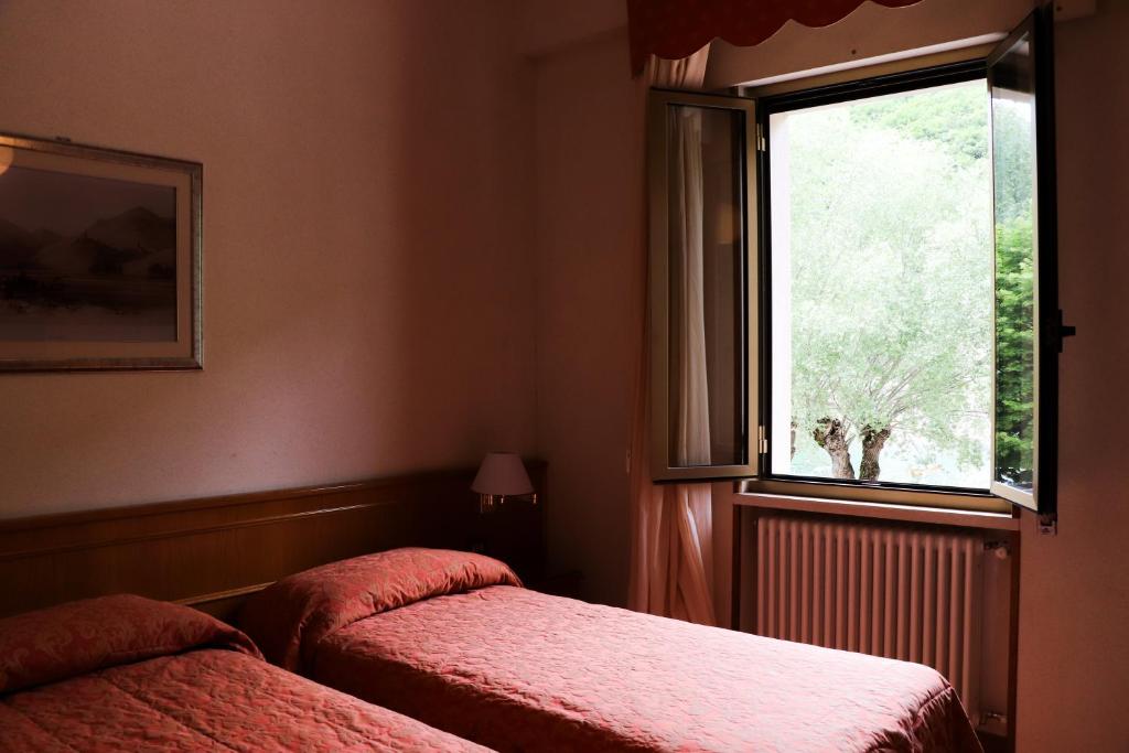 Postel nebo postele na pokoji v ubytování Hotel Garni del Lago