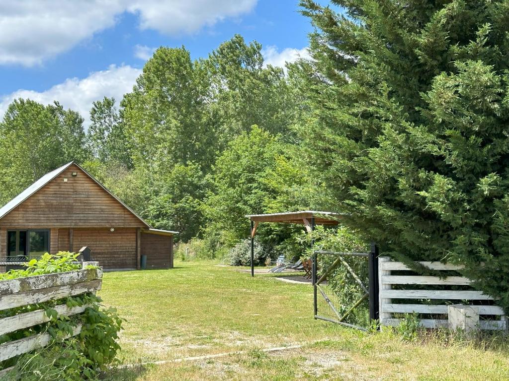 a barn and a fence in a yard at Le refuge de Chambord Nature, calme, forêt et prestige des châteaux de la Loire in Thoury