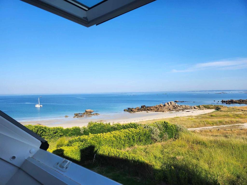 - une vue sur la plage avec un bateau dans l'eau dans l'établissement TREVIGNON - Ty Bihan Anna, à Trégunc