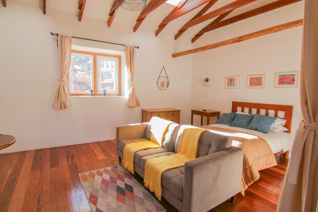 una camera da letto con un letto e un divano di SONQO, apartamento con lindas vistas en Cuesta san Blas 561 a Cuzco