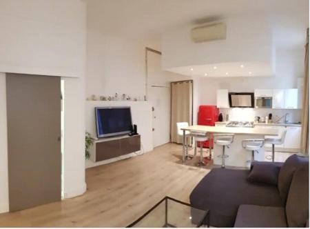 un salon avec un canapé et une cuisine dans l'établissement Coeur de ville AVIGNON, à Avignon