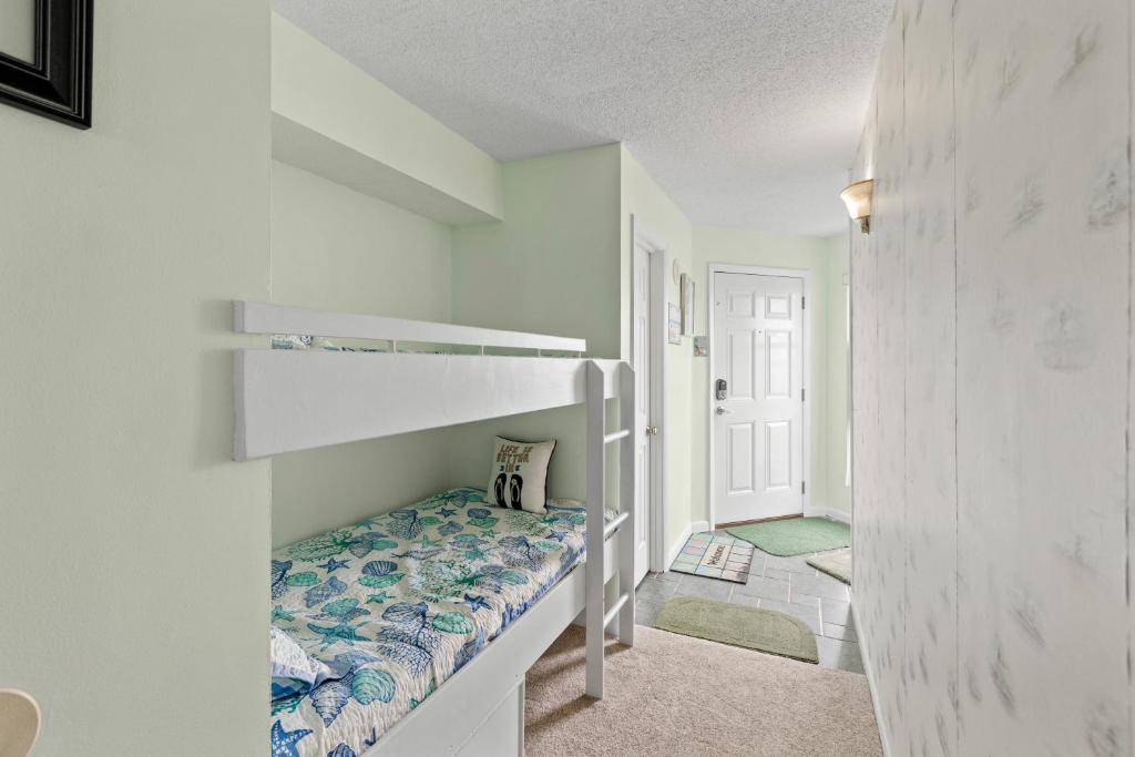 a small bedroom with a bunk bed in a room at Dolphins Den in North Topsail Beach