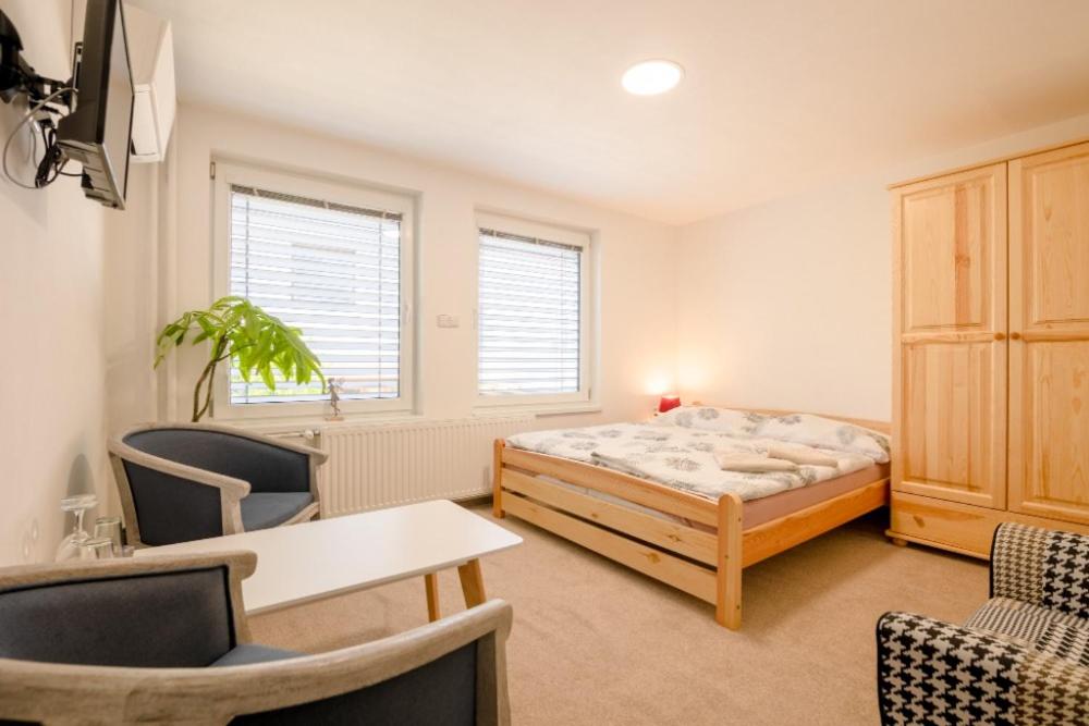 a bedroom with a bed and a table and chairs at Ubytování u Natálky in Valtice