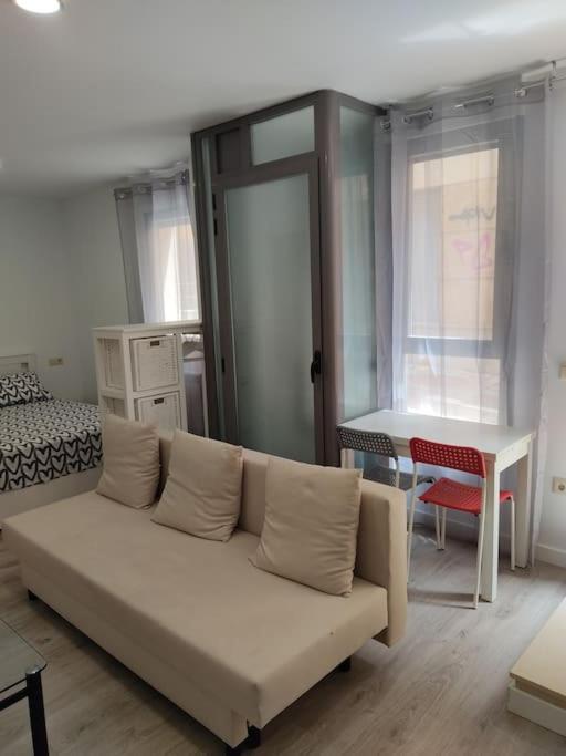 Una sala de estar con un sofá y un dormitorio. en Loft Albergueria, en Zamora