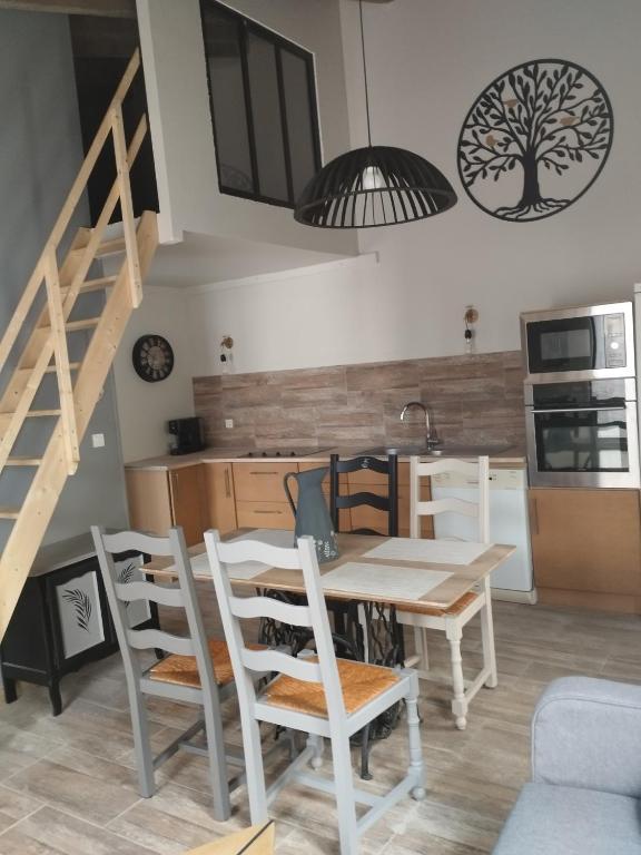 une cuisine et une salle à manger avec une table et des chaises dans l'établissement Jetez l'ancre, gîte La Tremblade, à La Tremblade