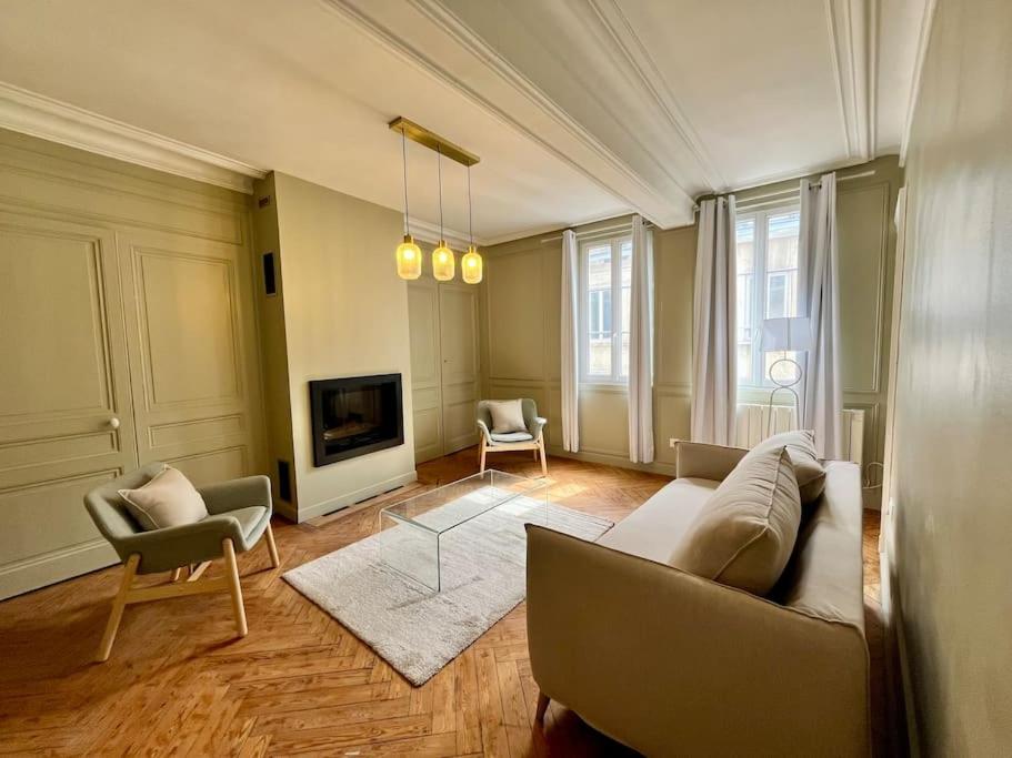 un salon avec un canapé, des chaises et une télévision dans l'établissement Emeraude, à Rouen