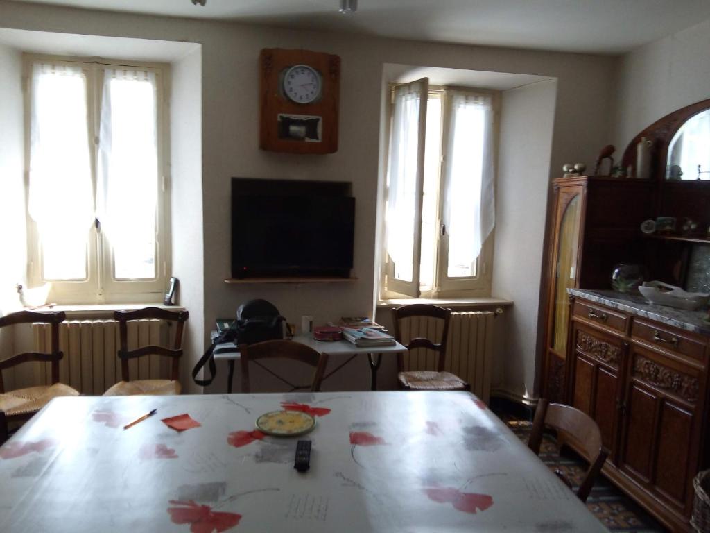 a living room with a table and a tv at Maison de village in Les Cammazes