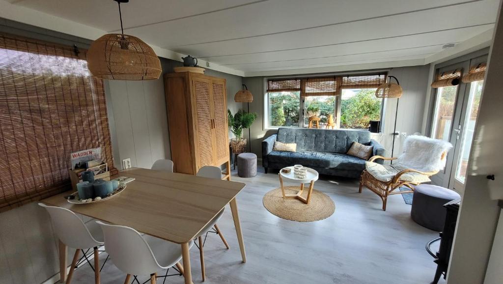a living room with a table and a couch at Chalet Joy aan Zee in Hollum