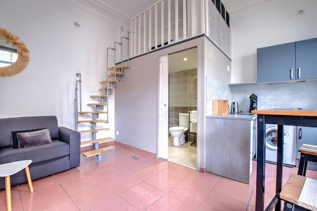 un salon avec un canapé bleu et une cuisine dans l'établissement Nid douillet, à Périgueux