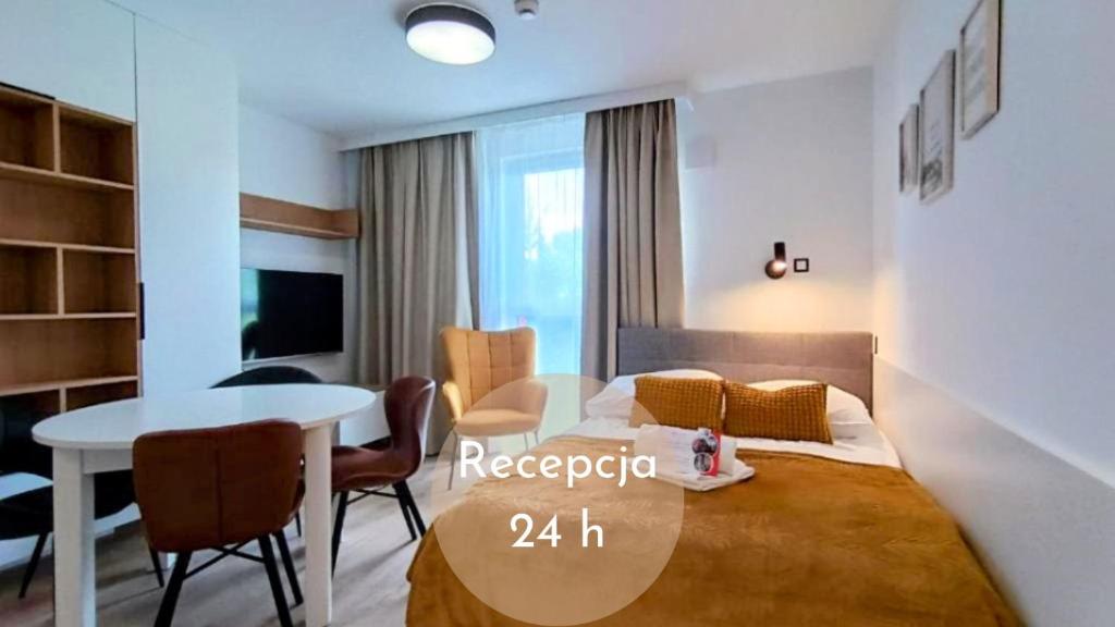 a bedroom with a bed and a table and a dining room at Ama Molto Apartments in Wrocław
