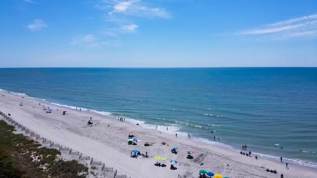a group of people on a beach near the ocean at Grande Shores in Myrtle Beach
