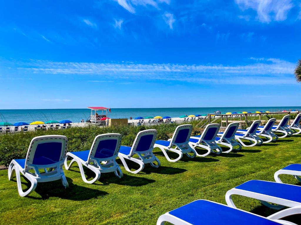 a row of blue and white chairs on the beach at Grande Shores in Myrtle Beach