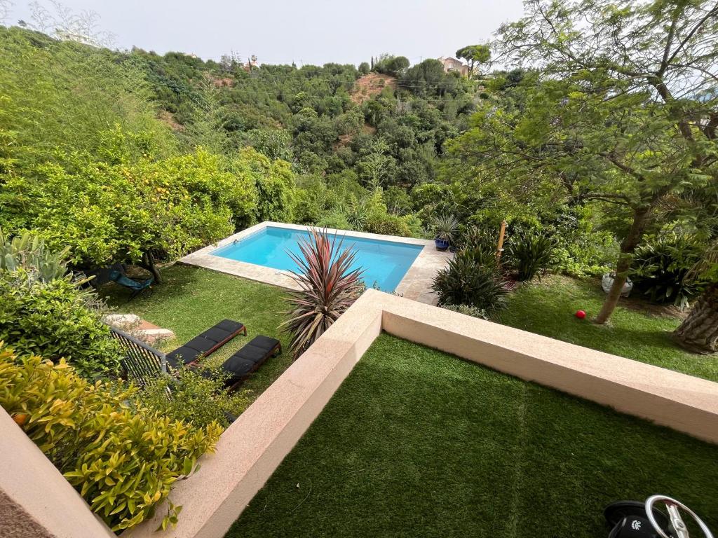 une piscine dans un jardin avec une pelouse dans l'établissement Bel appartement 4 pièces cosy, à Cannes