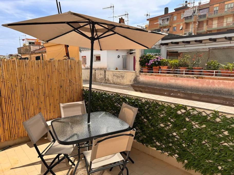 una mesa y sillas con una sombrilla en el balcón en Vicolo 9 e tre quarti, en Gaeta