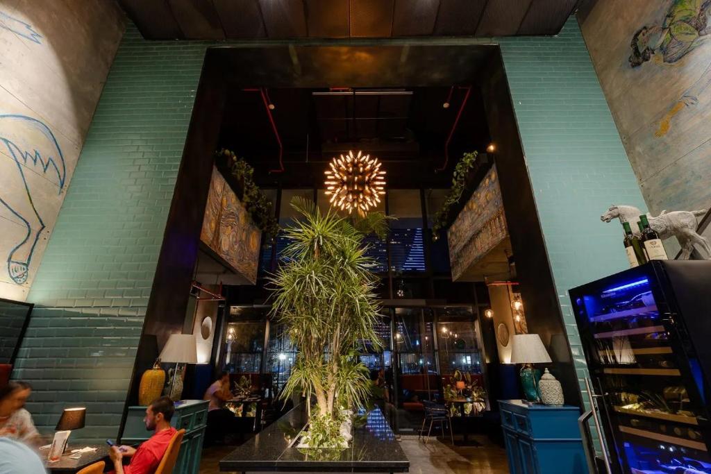 een restaurant met een tafel met een plant in het midden bij Black Sea Vi Dari Apartments in Batoemi