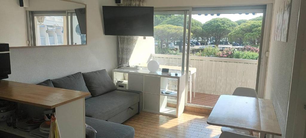 un salon avec un canapé et une table dans l'établissement Appartement 2 pièces Port-Camargue - Le Grau-du-Roi, Plage Sud, au Grau-du-Roi